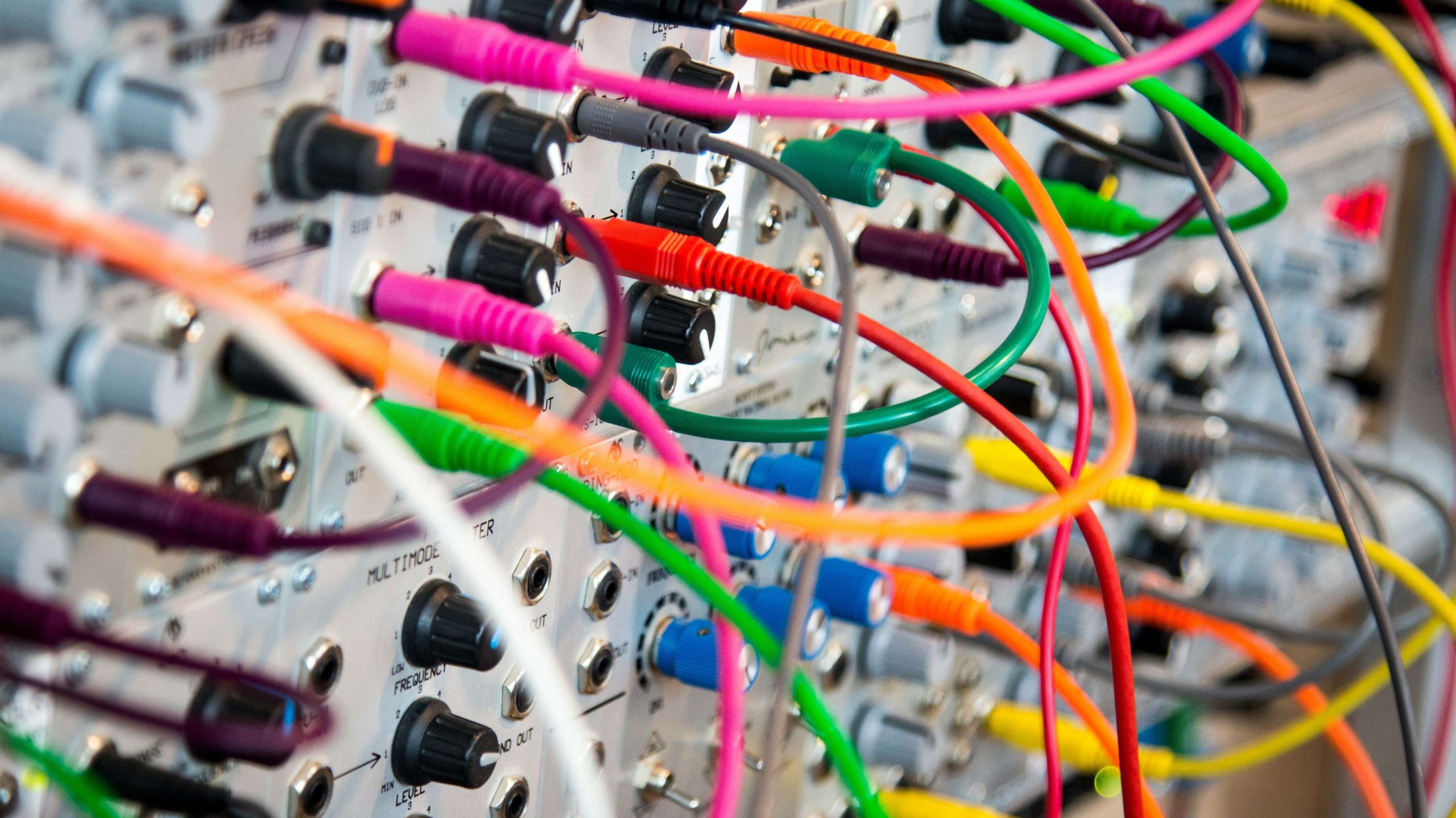 Colourful network cables connected into a communications rack